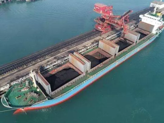 A picture of a cargo ship that's carrying coal to fuel the electric plants to charge the electric cars.