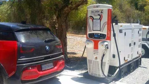 Here's an image that shows a car charging at a charging station that's run by diesel generator. In remote areas This Is How They have to charge electric cars because their power grids are not strong enough to deliver the electricity. Having to use a diesel generator means you're not helping the environment.