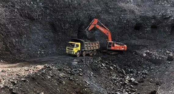 This is an image where they are stripping coal from the side of a hill also known as strip mining. This coal will be taken by train after being delivered to the train, to the electric plants so cars can be charged up.